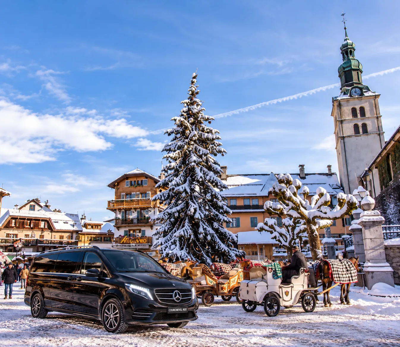 Black Mercedes V-Class van in the snow-covered village square of Megève